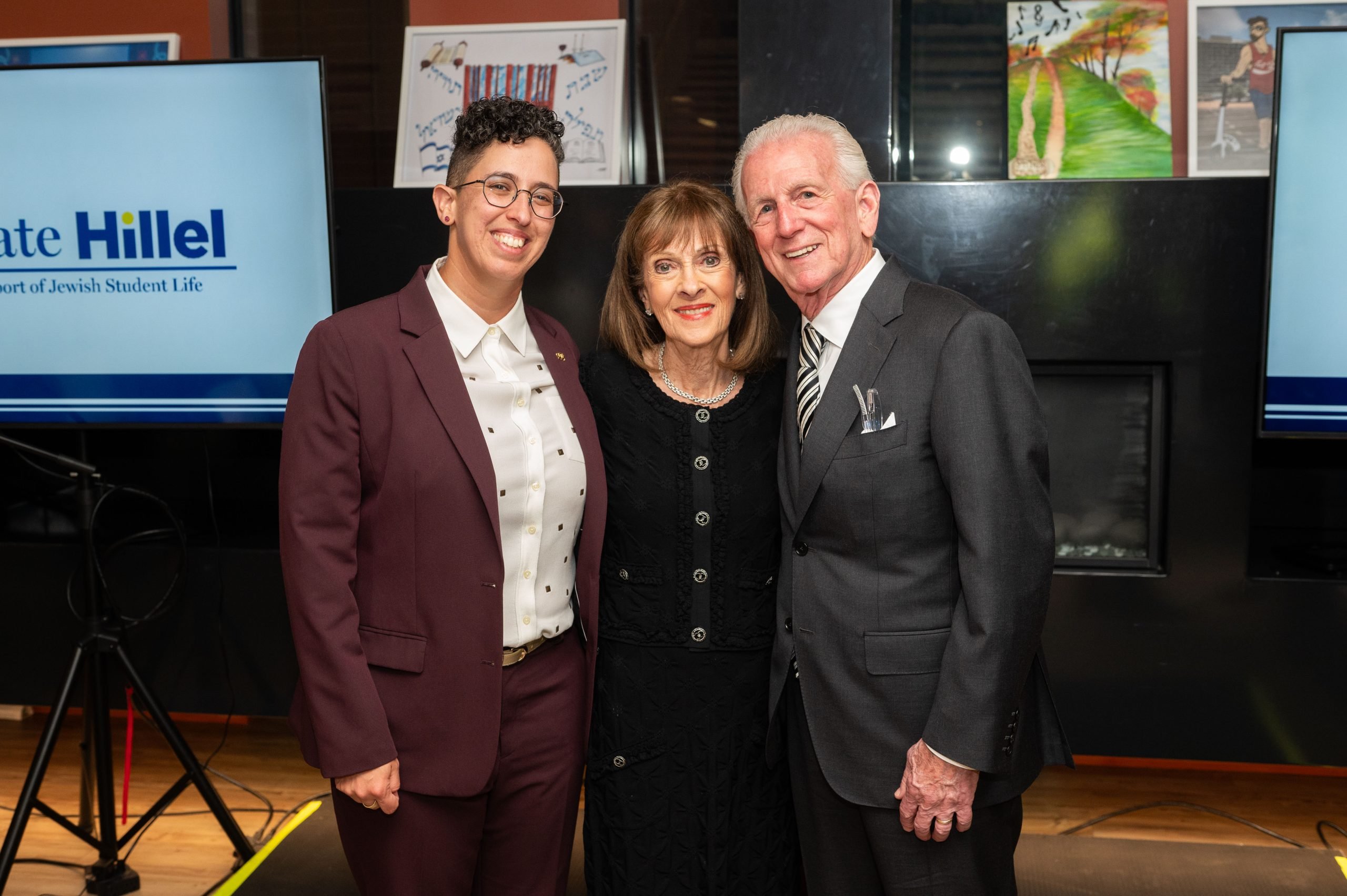Max and Sandi Paul with Rabbi Isabel de Koninck in front of the Perelman Center fireplace